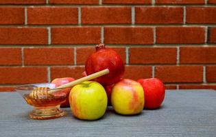 rosh hashanah jewesh holiday miel, pomme et grenade sur table en bois. symboles traditionnels. photo