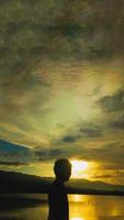 silhouette d'un homme sur fond de coucher de soleil sur le lac photo