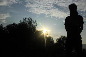 silhouette d'un homme au sommet d'une montagne photo