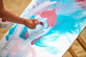 peintre amateur dessinant une image sur une toile blanche lors d'un exercice d'art en plein air, performance de peinture