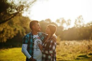 la famille passe du temps ensemble. femme et mari en chemises à carreaux au coucher du soleil. photo