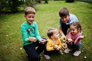 quatre enfants avec des beignets dans la cour du soir. délicieux beignets délicieux. photo