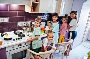 mère avec enfants cuisinant à la cuisine, moments heureux pour les enfants. photo