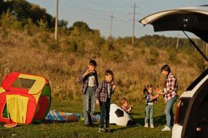 la famille passe du temps ensemble. quatre enfants avec leur mère mangent de la pastèque en plein air. photo