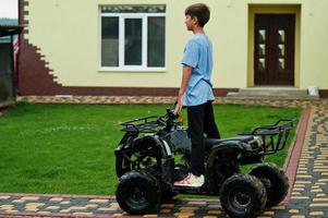 garçon en quad quad à quatre roues. photo