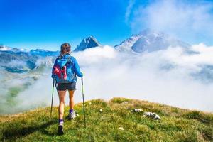 une fille lors d'une randonnée dans les montagnes avec des bâtons de poteaux photo