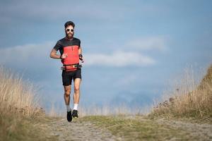 un athlète coureur avec une barbe s'entraîne sur une route de montagne photo