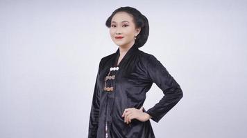 La beauté asiatique à kebaya a l'air élégante avec les mains sur la taille isolée sur fond blanc photo