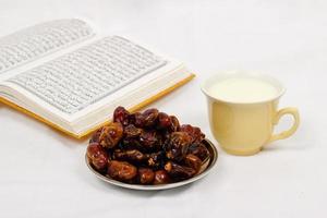 dates du coran et un verre de lait isolé sur fond blanc photo