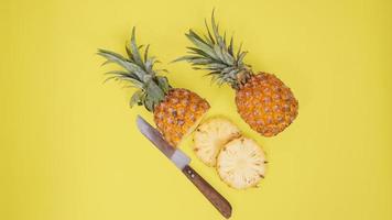 fruit d'ananas et certains de ses morceaux isolés sur fond jaune photo