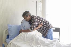 homme senior visitant une patiente cancéreuse portant un foulard à l'hôpital, soins de santé et concept médical photo