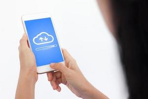 smartphone à portée de main ouvrant le concept de téléchargement dans le cloud sur l'écran du téléphone. téléchargement à la main d'une femme ou d'un homme depuis un téléphone mobile pour stocker des données sur le serveur. photo