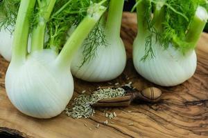 bulbes de fenouil vert et blanc sur bois d'olivier photo