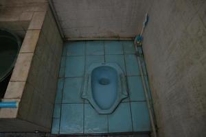toilettes à la turque avec sol bleu minable photo
