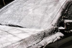 pare-brise de voiture recouvert d'une épaisse couche de neige après la tempête à l'extérieur photo