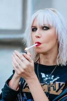 portrait d'une jeune femme élégante blonde grunge avec une cigarette de maquillage photo