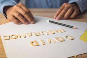 courtier présente sur l'assurance covid. textes en bois sur les documents. gros plan moyen avec espace de copie. photo