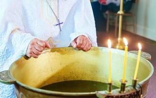 le baptême des chrétiens orthodoxes, la croix est descendue dans l'eau photo