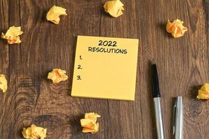 Inscription des résolutions 2022 sur des notes autocollantes jaunes photo