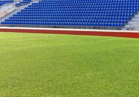 le champ vert vide et les sièges bleus du stade photo