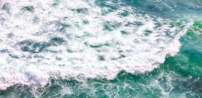 vue aérienne panoramique de l'océan bleu avec des vagues mousseuses pour le fond photo