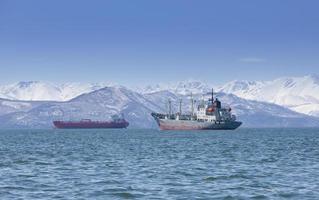 le grand bateau de pêche sur fond de collines et de volcans photo