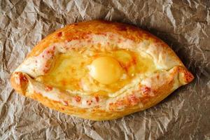 khachapuri appétissant sur parchemin pour la cuisson avec œuf à l'intérieur. cuisine géorgienne photo