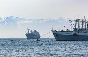 le grand bateau de pêche sur fond de collines et de volcans photo