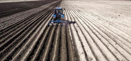 le tracteur laboure le champ au printemps vue arrière photo