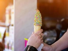 le vendeur donne la crème glacée dans une tasse à gaufres photo