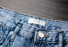 étiquette de vêtement vierge sur la texture des jeans en denim. étiquette avec un espace vide pour le texte photo