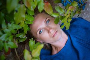 une femme blonde adulte se trouve dans les feuilles. photo