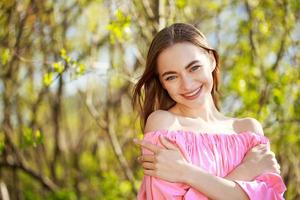 portrait d'une belle jeune femme souriante sur fond naturel photo