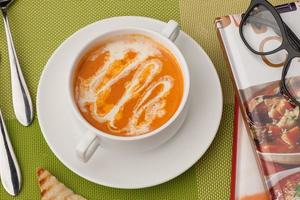 soupe et un livre sur une nappe verte photo