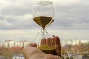 sablier dans les mains de l'homme. le temps de la vie humaine. le rapport de l'humanité et du temps. la courte vie de l'homme dans l'univers. photo