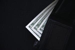 Billets d'un dollar et roubles d'un portefeuille noir photo
