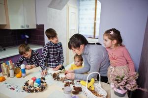 une mère de quatre enfants fabrique une couronne pour le réveillon de noël et fait de la décoration artisanale. Célébration du nouvel an. photo