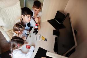 enfants utilisant un microscope apprenant des cours de sciences à la maison. photo