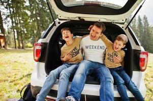 famille à l'intérieur du véhicule. père avec ses fils. enfants dans le coffre. voyager en voiture dans les montagnes, concept d'ambiance. photo