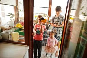 enfants tenant leurs animaux de compagnie préférés sur les mains. les enfants jouent avec le hamster, la tortue et les perroquets à la maison. photo