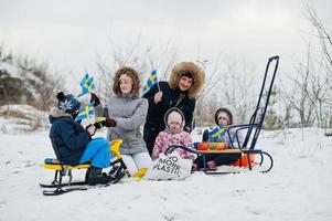 famille scandinave avec le drapeau de la suède dans le paysage suédois d'hiver. photo