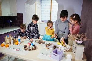 une mère de quatre enfants fabrique une couronne pour le réveillon de noël et fait de la décoration artisanale. Célébration du nouvel an. photo