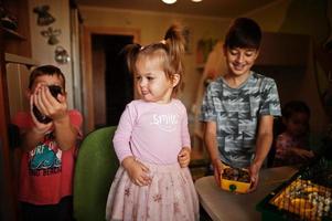 quatre enfants tenant leurs animaux de compagnie préférés sur les mains. les enfants jouent avec le hamster, la tortue et les perroquets à la maison. photo