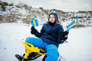 garçon scandinave avec le drapeau de la suède dans le paysage suédois d'hiver. photo