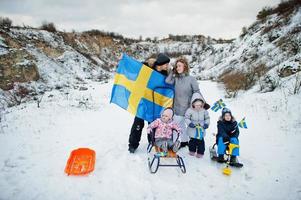 famille scandinave avec le drapeau de la suède dans le paysage suédois d'hiver. photo