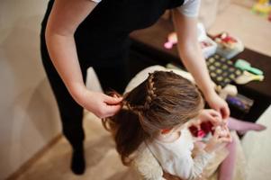 week-end mère et fille ensemble à la maison, maman faisant la coiffure. photo