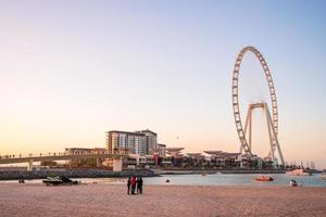 bel oeil de dubai ou ain dubai sur la plage de jumeirah au coucher du soleil. coucher de soleil magique à dubaï près de la grande roue. photo
