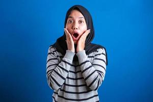 portrait d'une jolie jeune étudiante musulmane asiatique portant le hijab montre une expression surprise ou choquée photo