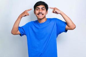 homme portant une chemise décontractée souriant pointant vers la tête avec le doigt des deux mains, bonne idée ou pensée photo