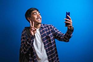 un homme asiatique heureux sourit a regardé la caméra sur fond bleu photo